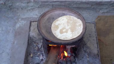 Geleneksel Hint usulü Roti ya da Chapati HEarth 'de Pişirme ya da Pişirme. Roti ya da Hint Chapati yapmak Roti tawa 'da, el yapımı buğday.
