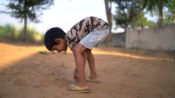 一个小男孩的脏手正挖在干枯的泥巴里 笑着的亚洲小男孩开开心心地挖沙子 — 图库视频影像