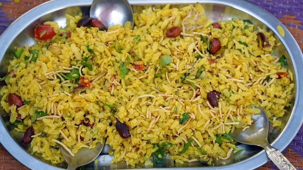 Indian Breakfast Dish Poha Also Know as Pohe or Aalu poha made up of Beaten Rice or Flattened Rice. The rice flakes are lightly fried in oil with mustard, turmeric, onion, curry leaves