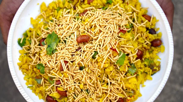 Indian Breakfast Dish Poha Also Know as Pohe or Aalu poha made up of Beaten Rice or Flattened Rice. The rice flakes are lightly fried in oil with mustard, turmeric, onion, curry leaves