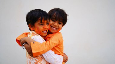 Renkli gülümseyen mutlu Hintli çocuklar mı yoksa Holi 'yi kutlayan Asyalı çocuklar mı? Hint festivali için Holi kavramı. Renkli toza bulanmış parlak çocuklar.