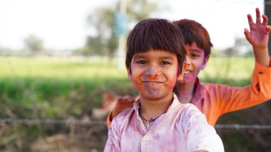 Renkli gülümseyen mutlu Hintli çocuklar mı yoksa Holi 'yi kutlayan Asyalı çocuklar mı? Hint festivali için Holi kavramı. Renkli toza bulanmış parlak çocuklar.