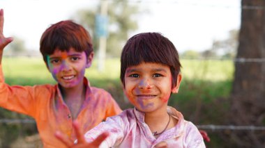 Renkli gülümseyen mutlu Hintli çocuklar mı yoksa Holi 'yi kutlayan Asyalı çocuklar mı? Hint festivali için Holi kavramı. Renkli toza bulanmış parlak çocuklar.