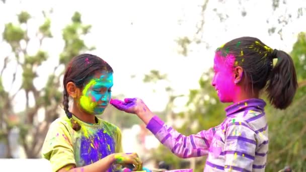 Holi를 축하하는 아시아 아이들의 얼굴에 색으로 색상을 재생하는 행복한 소녀의 — 비디오