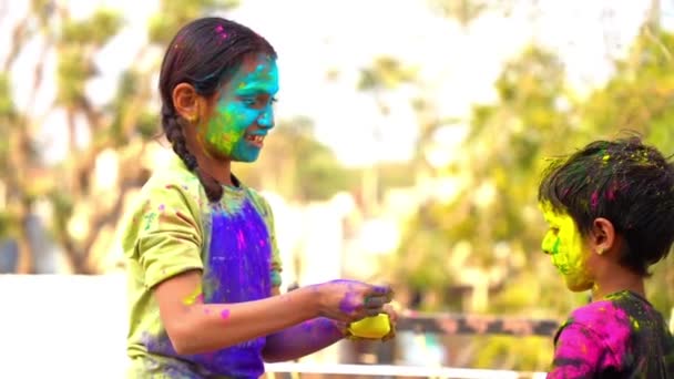 Holi를 축하하는 아시아 어린이의 얼굴에 색상으로 행복한 동생과 여동생의 비디오 — 비디오