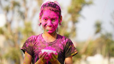 Holi festivali kutlamalarında renkli elleri kameraya gösteren uygulamalı holi rengi pudralı küçük sevimli çocuklar.