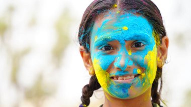 Mutlu şirin, gülümseyen küçük Hintli çocuklar renkli ellerini ya da avuç içini gösteriyorlar ya da renkli Holi festivali oynuyorlar.