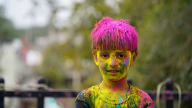 Renkli gülümseyen mutlu Hintli çocuklar mı yoksa Holi 'yi kutlayan Asyalı çocuklar mı? Hint festivali için Holi kavramı. Renkli toza bulanmış parlak çocuklar.
