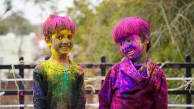Renkli gülümseyen mutlu Hintli çocuklar mı yoksa Holi 'yi kutlayan Asyalı çocuklar mı? Hint festivali için Holi kavramı. Renkli toza bulanmış parlak çocuklar.