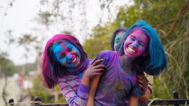 Holi Festivali sırasında çocuklar renkli tozla kaplıydı. Mutlu Asyalı çocuklar Hint Holi festivalini yüzlerinde renkli boya tozuyla kutluyorlar.