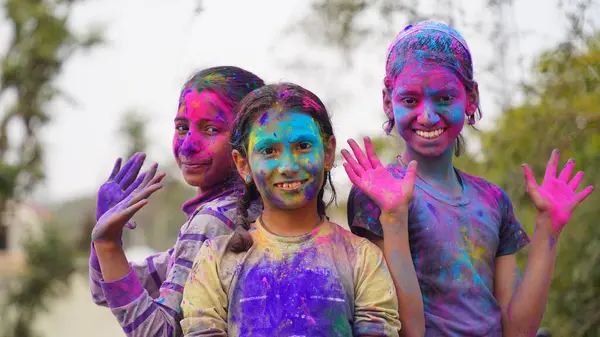 Happy Cute Smiling little Indian kids showing their colourful hands or palm printing or playing holi festival with colours