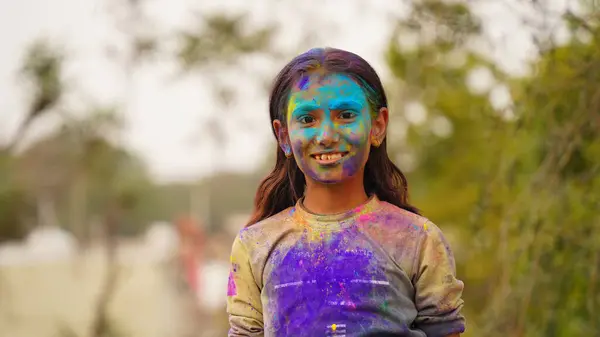 Children covered in colored powder during the festival of Holi. Happy Cute Asian kids celebrate Indian holi festival with colorful paint powder on faces and bod