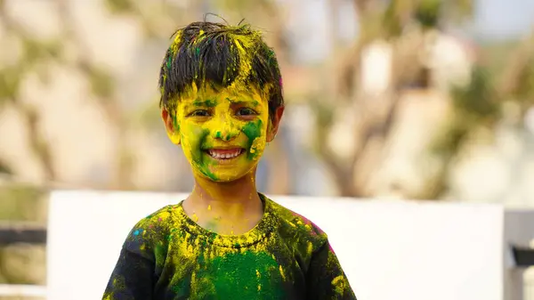 Children covered in colored powder during the festival of Holi. Happy Cute Asian kids celebrate Indian holi festival with colorful paint powder on faces and bod