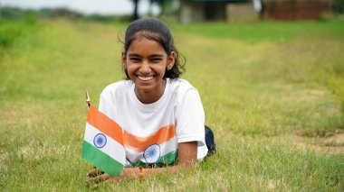 Hintli öğrenci ya da çocuklar arka planda yeşille üç renkli el sallayarak Bağımsızlık Günü 'nü ya da Cumhuriyet Günü' nü kutluyorlar. Har Ghar Tiranga
