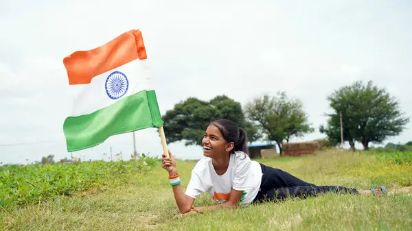 stock image Indian student or children holding or waving Tricolour with greenery in the background, celebrating Independence or Republic day. Har Ghar Tiranga