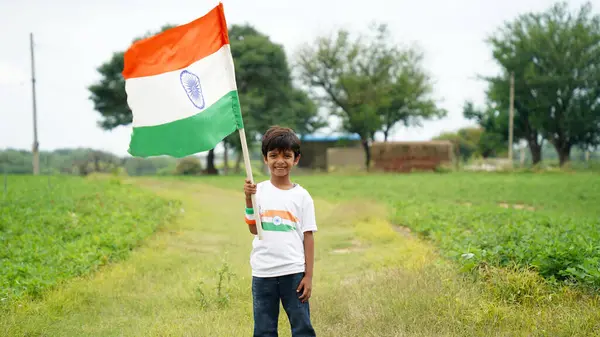 stock image Little boy wearing indian tricolor Tshirt, face painted with triclolor and saluting. Celebrating Independnce day or Republic day. Har Ghar Tiranga