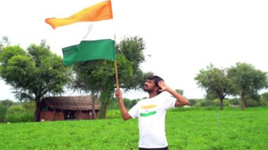 Beyaz ırk kökenli yakışıklı Hintli genç adam Hindistan ulusal bayrağının bebeğini giyiyor ve vatanseverlik gösteriyor. Har Ghar Tiranga