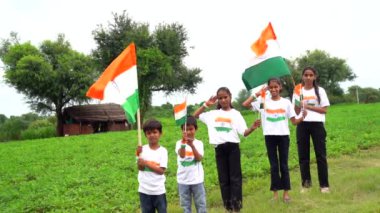 Bir grup öğrenci ya da üç renkli Hint tişörtü giyen bir grup çocuk, yüzü üç renkli renklerle boyanmış ve selam veriyor. Bağımsızlık ya da Cumhuriyet Günü 'nü kutluyoruz. Har Ghar Tiranga