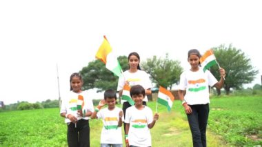 Bir grup öğrenci ya da üç renkli Hint tişörtü giyen bir grup çocuk, yüzü üç renkli renklerle boyanmış ve selam veriyor. Bağımsızlık ya da Cumhuriyet Günü 'nü kutluyoruz. Har Ghar Tiranga