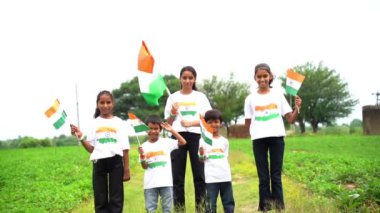 Bir grup öğrenci ya da üç renkli Hint tişörtü giyen bir grup çocuk, yüzü üç renkli renklerle boyanmış ve selam veriyor. Bağımsızlık ya da Cumhuriyet Günü 'nü kutluyoruz. Har Ghar Tiranga