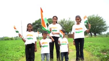 Bir grup öğrenci ya da üç renkli Hint tişörtü giyen bir grup çocuk, yüzü üç renkli renklerle boyanmış ve selam veriyor. Bağımsızlık ya da Cumhuriyet Günü 'nü kutluyoruz. Har Ghar Tiranga