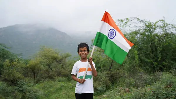 stock image Handsome cute little Indian boy or kid in white ethnic wear standing infant of indian national flag and showing patriotism. Har Ghar Tiranga