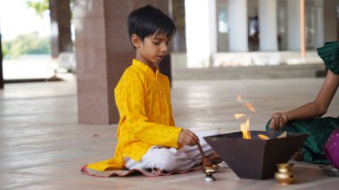 Bir Hindu ailesi, Yagya için bir festival kutlamasında kutsal ateşin etrafında toplanıyor. Havan ve pooja ritüelleri arasında adaklar ve ruhani uyum ve refah için Vedic mantraları yer alıyor.