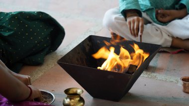 A Hindu family gathers around a sacred fire for Yagya during a festival celebration. The Havan and pooja rituals include offerings and Vedic mantras for spiritual harmony and prosperity clipart