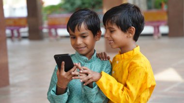 Mutlu genç erkek öğrenci cep telefonu uygulaması kullanıyor alışveriş alışverişi yapıyor sosyal ağda yeni arkadaşlar arıyor. Gülümseyen milenyum çocuğu hücre hapsi. Alet ekranına bak. İyi haberleri oku.