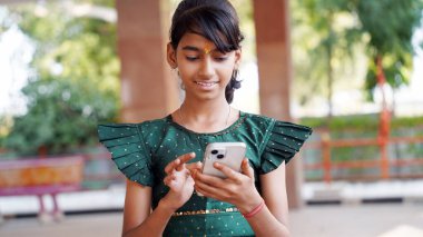 Mutlu genç kız öğrenci cep telefonu uygulaması kullanıyor alışveriş alışverişi yapıyor sosyal ağda yeni arkadaşlar arıyor. Gülümseyen milenyum kızı hücre hapsi. Alet ekranına bak. İyi haberleri oku.