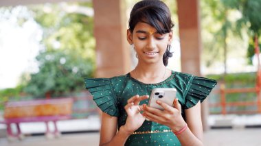 Genç kız cep telefonu kullanıyor sosyal medyada mesajlaşmalar paylaşıyor, yeni video bloğunun keyfini çıkarıyor, internetin işe ara vermesini dizüstü bilgisayarla izliyor. Teknoloji, e-servis, mobil uygulama kullanımı kavramı