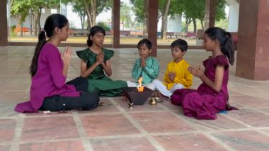 Geleneksel kıyafetli bir Hintli aile, evlerinde enerjilerini dengelemek için bir rahip tarafından yönetilen Yagya veya Havan 'ı icra eder. Bu kutsal pooja uyum ve pozitif enerji içindir..