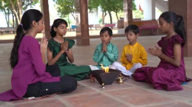 Geleneksel kıyafetli bir Hintli aile, evlerinde enerjilerini dengelemek için bir rahip tarafından yönetilen Yagya veya Havan 'ı icra eder. Bu kutsal pooja uyum ve pozitif enerji içindir..