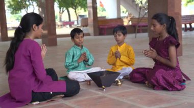 Geleneksel kıyafetli bir Hintli aile, evlerinde enerjilerini dengelemek için bir rahip tarafından yönetilen Yagya veya Havan 'ı icra eder. Bu kutsal pooja uyum ve pozitif enerji içindir..
