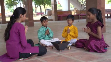 Geleneksel kıyafetli bir Hintli aile, evlerinde enerjilerini dengelemek için bir rahip tarafından yönetilen Yagya veya Havan 'ı icra eder. Bu kutsal pooja uyum ve pozitif enerji içindir..