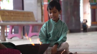 Geleneksel kıyafetli bir Hintli aile, evlerinde enerjilerini dengelemek için bir rahip tarafından yönetilen Yagya veya Havan 'ı icra eder. Bu kutsal pooja uyum ve pozitif enerji içindir..