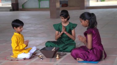 Geleneksel kıyafetli bir Hintli aile, evlerinde enerjilerini dengelemek için bir rahip tarafından yönetilen Yagya veya Havan 'ı icra eder. Bu kutsal pooja uyum ve pozitif enerji içindir..