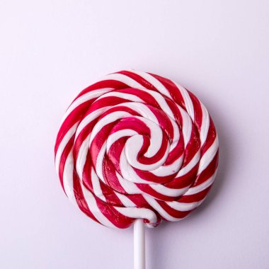 Kırmızı ve beyaz çizgili lolipop, çubukta şeker.