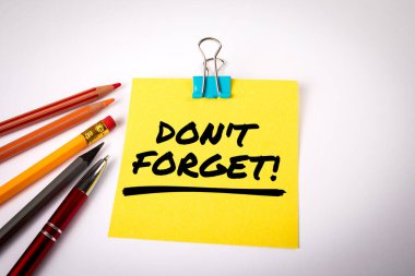 Sakın unutma. Sarı not kağıdına mesaj at. Beyaz ofis masası.