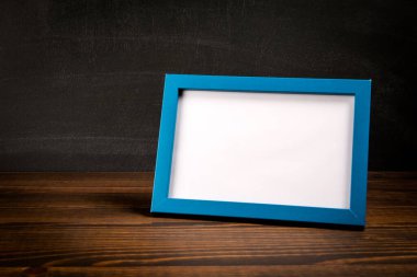 Ahşap masaya boş resim çerçevesi. Model.