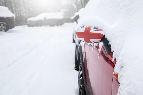 Snowy parking lot. Snowfall and storm. British flag.