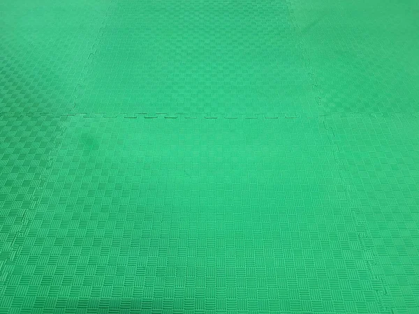 Green rubber mat for sports and childrens playground.