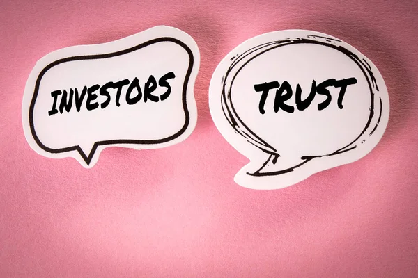 Investors trust concept. Two speech bubbles with text on a pink background.