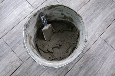 Bir kova fayans yapıştırıcısı ve bir mala. Onarımlar ve inşaat.