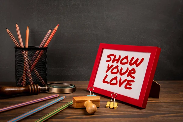Show Your Love. Text in picture frame. wood texture office desk.