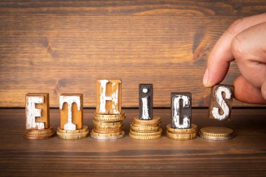 ETHICS. Business and attitude concept. Text and money on wood texture background.