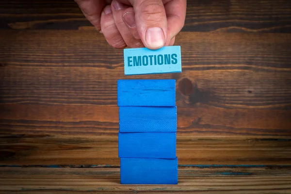 EMOTIONS. Psychology and mental health. Blue blocks in a pile on a wooden background.