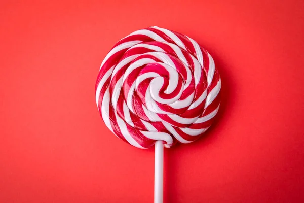Candy on a stick, lollipop. Red background.