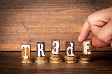 TRADE. Concept of finance and economics. Text and money on a wooden background.