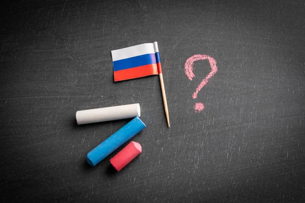 Russian aggression and sanctions. Flag on a dark chalkboard.